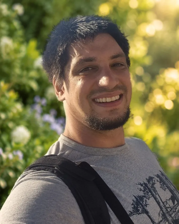 Kevin Geiser, Geschäftsführer von Geiser Gartenbau, vor einer grünen Gartenhecke